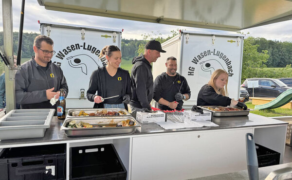 Mitarbeitende bereiten am Grillbuffet Speisen für den Hornusser-Event der HG Wasen-Lugenbach zu.