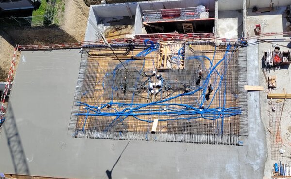 Luftaufnahme der Baustelle der Überbauung Bärengarten in Madiswil mit betonierten Flächen, Armierungen und Installationsleitungen.