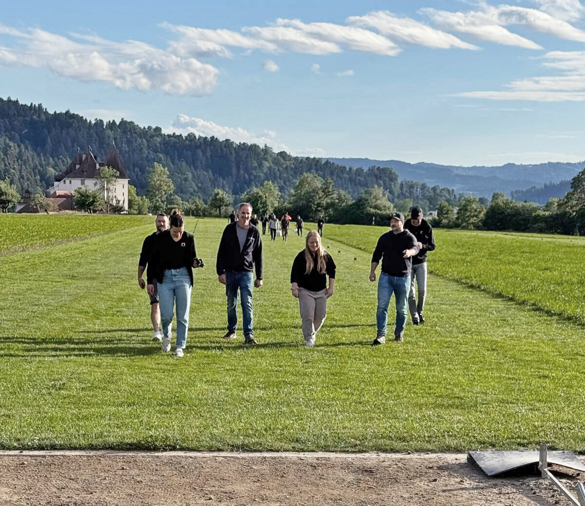 Gruppe kehrt nach dem Hornussen über das Spielfeld zum Abschlagplatz zurück.