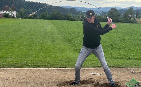 Teilnehmer beim Abschlag mit dem Hornusserstecken auf dem Spielfeld in Wasen.