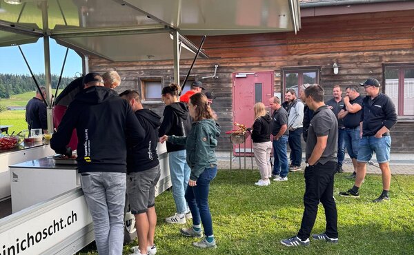 Gäste bedienen sich am Grillbuffet vor dem Hornusserhaus.